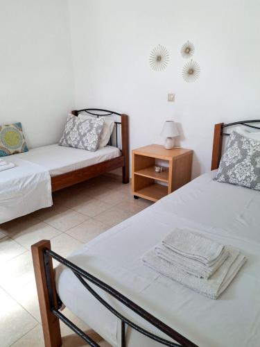 a room with two beds and a table with a chair at My Plaka Beach Vacation Home in Plaka