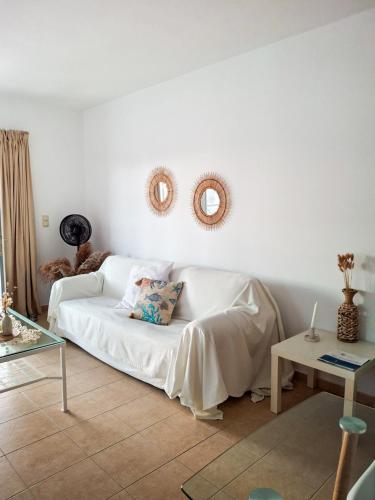 a living room with a white couch and a table at My Plaka Beach Vacation Home in Plaka