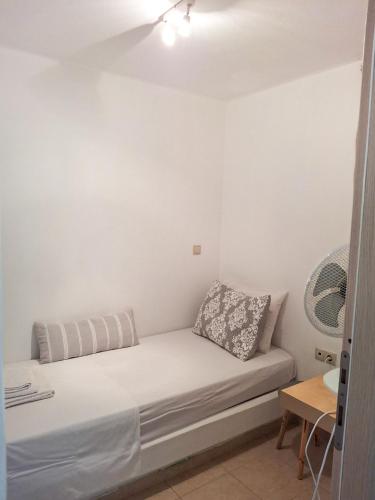 a white couch in a room with a fan at My Plaka Beach Vacation Home in Plaka