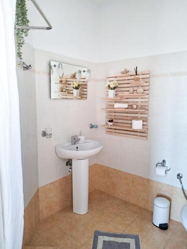 a white bathroom with a sink and a mirror at My Plaka Beach Vacation Home in Plaka