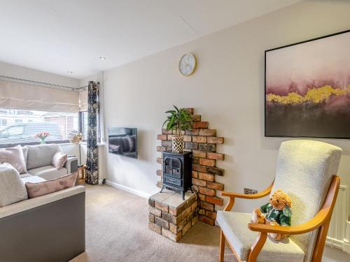 a living room with a fireplace and a couch at Tulip - Uk48836 in Skegness