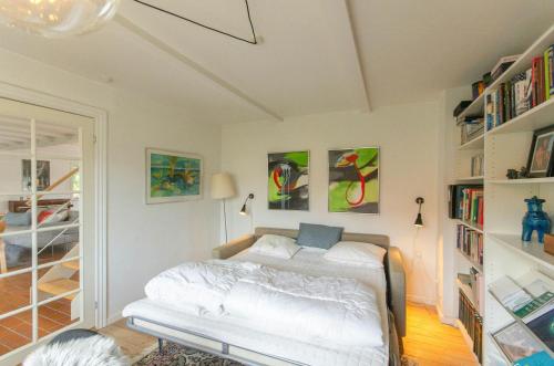 a bedroom with a bed and a book shelf at Historic Fisherman's House At Bønnerup Beach in Bønnerup