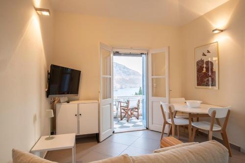 a living room with a table and a tv at Endless Blue, Your Seaside Escape in Plati Gialos in Kamári