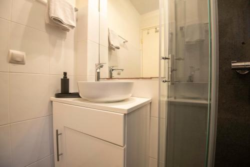 a white bathroom with a sink and a shower at Endless Blue, Your Seaside Escape in Plati Gialos in Kamári