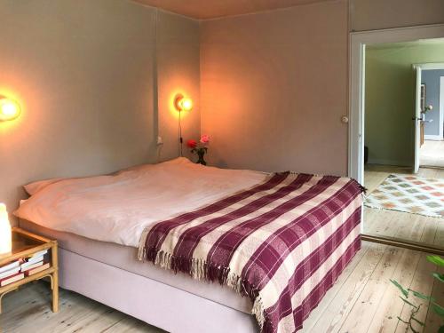 a bedroom with a bed with a striped blanket on it at Forest Ranger's House With Sea View In Kalvehave in Kalvehave