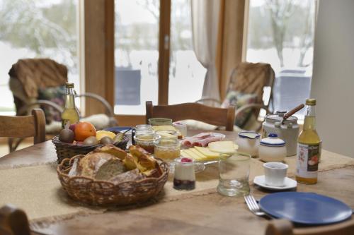 a table with a basket of food and bottles of wine at La yourte de l'Abreuvoir in Neufchâteau