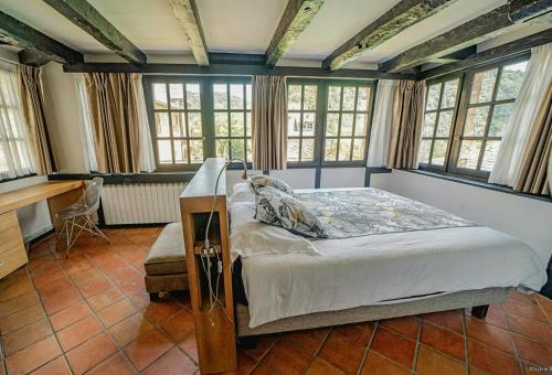 MonteilsにあるCharming House Overlooking Aveyron Valleyのベッドと机と窓のある寝室