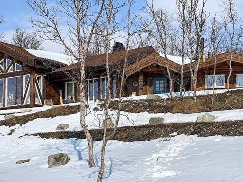 ein Haus im Schnee mit einem Baum davor in der Unterkunft Log Cabin With Panoramic Views Of Hallingskarvet in Hovet