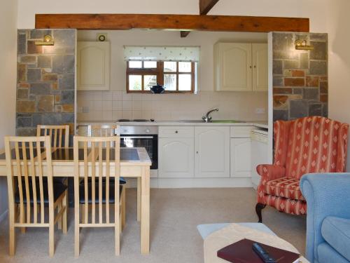 a kitchen and living room with a table and chairs at The Hay Barn in Sidbury