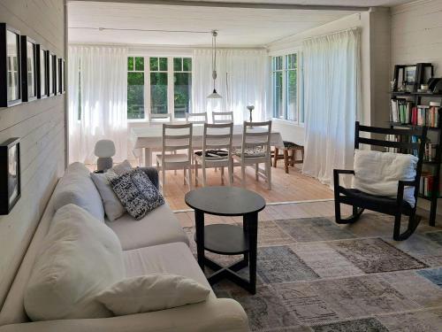 un salon avec un canapé et une salle à manger dans l'établissement Traditional Cottage Near Linné's Råshult, à Stenbrohult