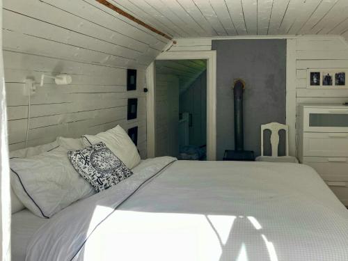 une chambre avec un lit blanc dans une pièce dans l'établissement Traditional Cottage Near Linné's Råshult, à Stenbrohult