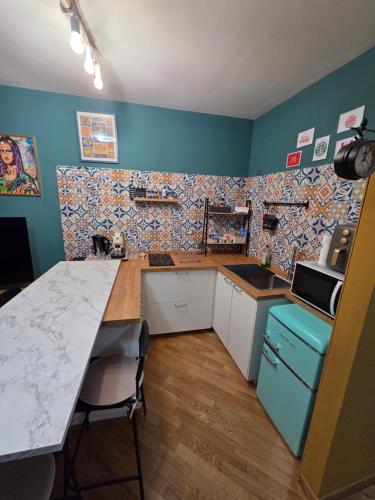 a kitchen with blue walls and a counter with a table at B&B NewYork, Avellino in Avellino