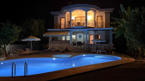 a house with a swimming pool in front of it at night at Villa Ahmet Dalyan 4 bedrooms in Dalyan