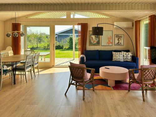 a living room with a blue couch and a table at Colourful Holiday Home Near Middelfart Beach in Voldby