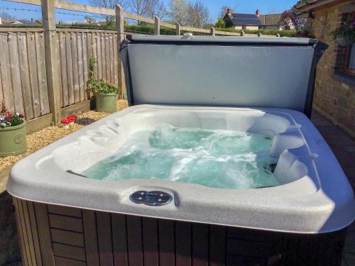 une baignoire jacuzzi installée dans une cour dans l'établissement Whitney Cottage, à Broadway