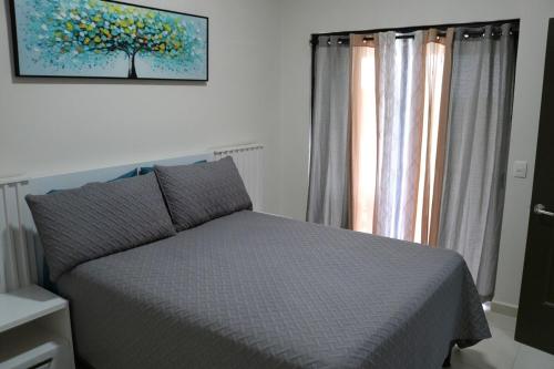 ein Schlafzimmer mit einem Bett und einem Baumgemälde an der Wand in der Unterkunft Mi Casita San Miguel in San Miguel