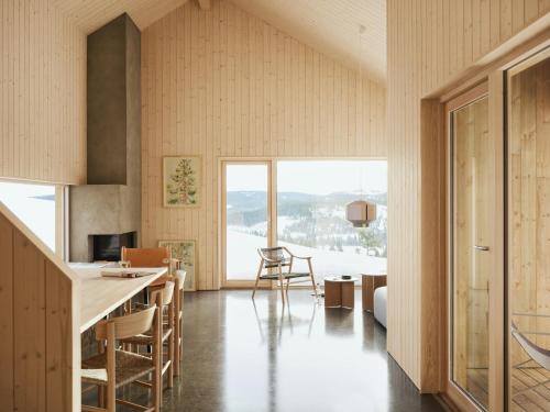 a kitchen and dining room with a large window at Architect-Designed Cabin With Lake Mylla Views in Roa
