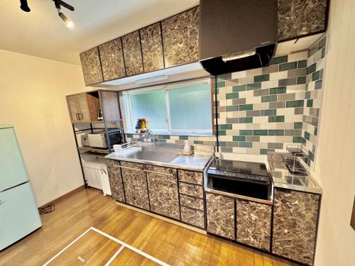 a kitchen with a sink and a counter top at Grand Open!! Guest House 圭堂-Seidou- Free for rental bicycle and the washing machine and dry machine!!自転車レンタル無料!!無料ランドリー有!! in Fujiyoshida