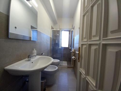 a white bathroom with a sink and a toilet at Casa Sapio vista mare in Pace Inferiore
