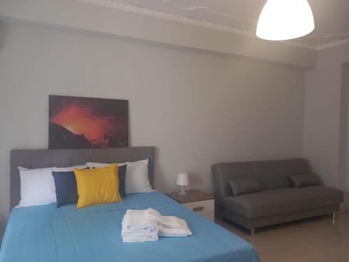 a bedroom with a blue bed with a couch at Casa Sapio vista mare in Pace Inferiore
