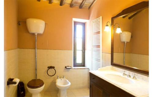 Un baño con inodoro, lavabo y espejo. en Siena Private Pool Villa, en Belforte