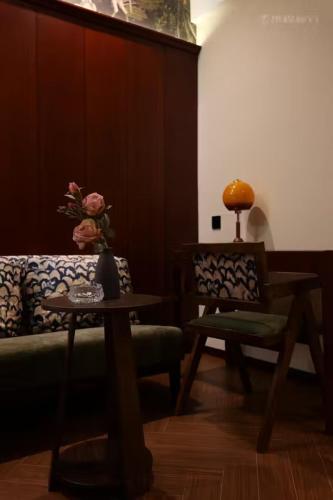 uma sala de estar com um sofá, uma mesa e uma cadeira em Yushan Hall em Chongqing