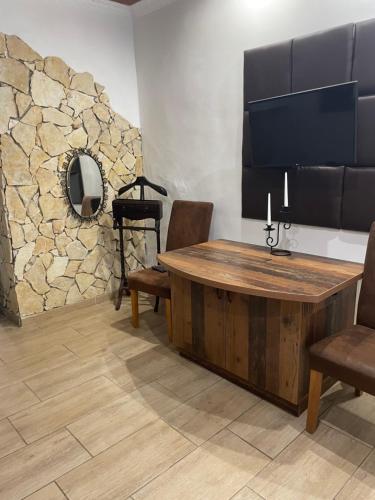 a room with a table and chairs and a flat screen tv at Hacienda Apartman in Békéscsaba