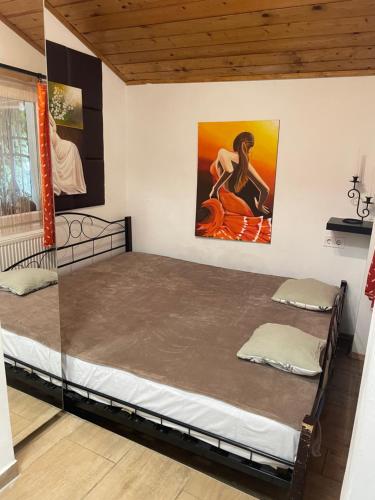 two beds in a room with a painting on the wall at Hacienda Apartman in Békéscsaba