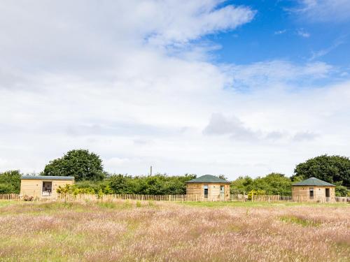 two houses in a field with a fence at Olive in Wootton Bridge