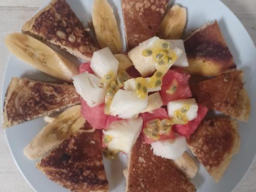a white plate of food with toast and fruit at Eco lodge finca magdalena in Altagracia