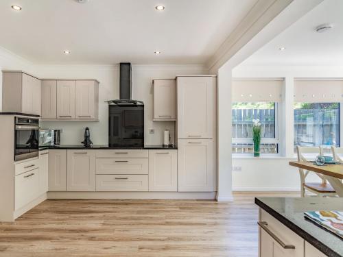 a kitchen with white cabinets and a counter top at Headland View in Banff