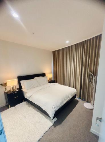a bedroom with a bed and a window with curtains at WiiHost Cosy Retreat! in Melbourne