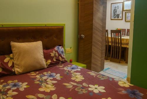 a bedroom with a bed with a flowery bedspread and a pillow at Officers abode in Nashik