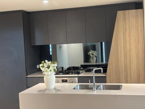 a kitchen with a vase of flowers on a counter at WiiHost Cosy Retreat! in Melbourne
