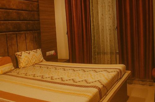 a bed sitting in a room with a curtain at Officers abode in Nashik