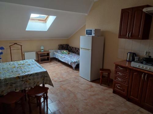 a kitchen with a refrigerator and a table with a tableablish at DOBA - Центр 1 кім 5 міс Завжди тепла ! in Mukacheve