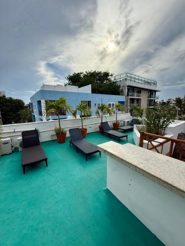 a balcony with chairs and blue water on a building at SelvaMar Estudios Playa in Playa del Carmen