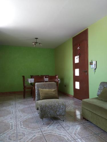 a living room with green walls and a couch and a table at B1-Departamento Bolognesi in Chiclayo
