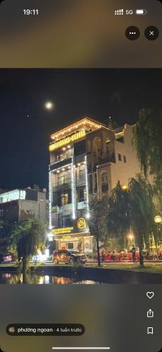 a building at night with cars parked in front of it at MD Hotel in Mỹ Lộc