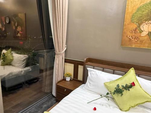 a bedroom with a bed with a yellow pillow and a window at MD Hotel in Mỹ Lộc