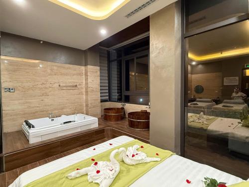 a bathroom with two swans on a bed and a tub at MD Hotel in Mỹ Lộc