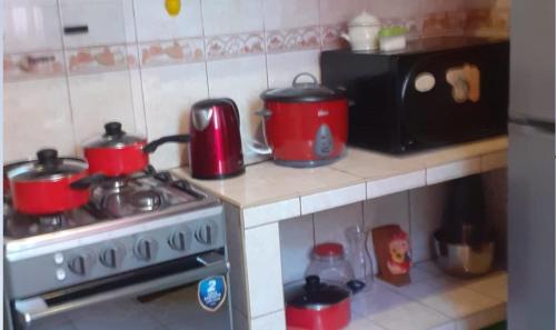 a kitchen with red pots and pans on a stove at B1-Departamento Bolognesi in Chiclayo