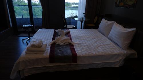 a bedroom with a bed with towels and slippers at MD Hotel in Mỹ Lộc