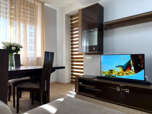 a living room with a television and a dining table at Luxury 2-bedroom Apartments on 13 Buzand street by Sweet Home in Yerevan