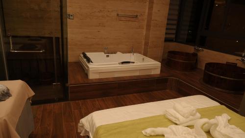 a bathroom with a tub and a sink and two beds at MD Hotel in Mỹ Lộc