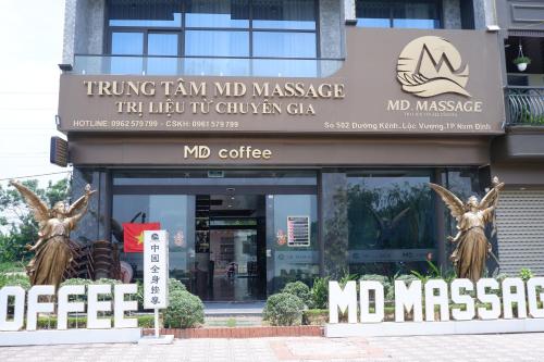 a building with two statues in front of it at MD Hotel in Mỹ Lộc