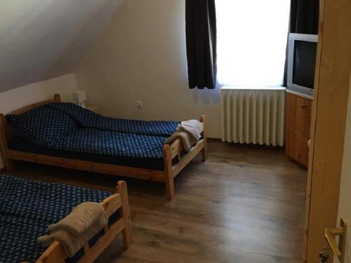 a bedroom with two twin beds and a window at Fitt Magánszálláshely in Sásd