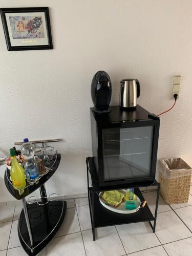 a table with a coffee pot on top of a tv at Studio-Apartment mit Balkon in Plau am See fußläufig zum Strand und zur Altstadt in Plau am See