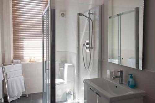 uma casa de banho com um chuveiro e um lavatório. em Villa Lavinia em Ventnor