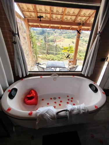 a bath tub with a red heart inside of it at REFUGIO PIEMONTE Chalés in Socorro